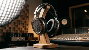 Offener Over-Ear-Kopfhörer mit Holz-Ohrmuscheln auf einem Ständer im Studio